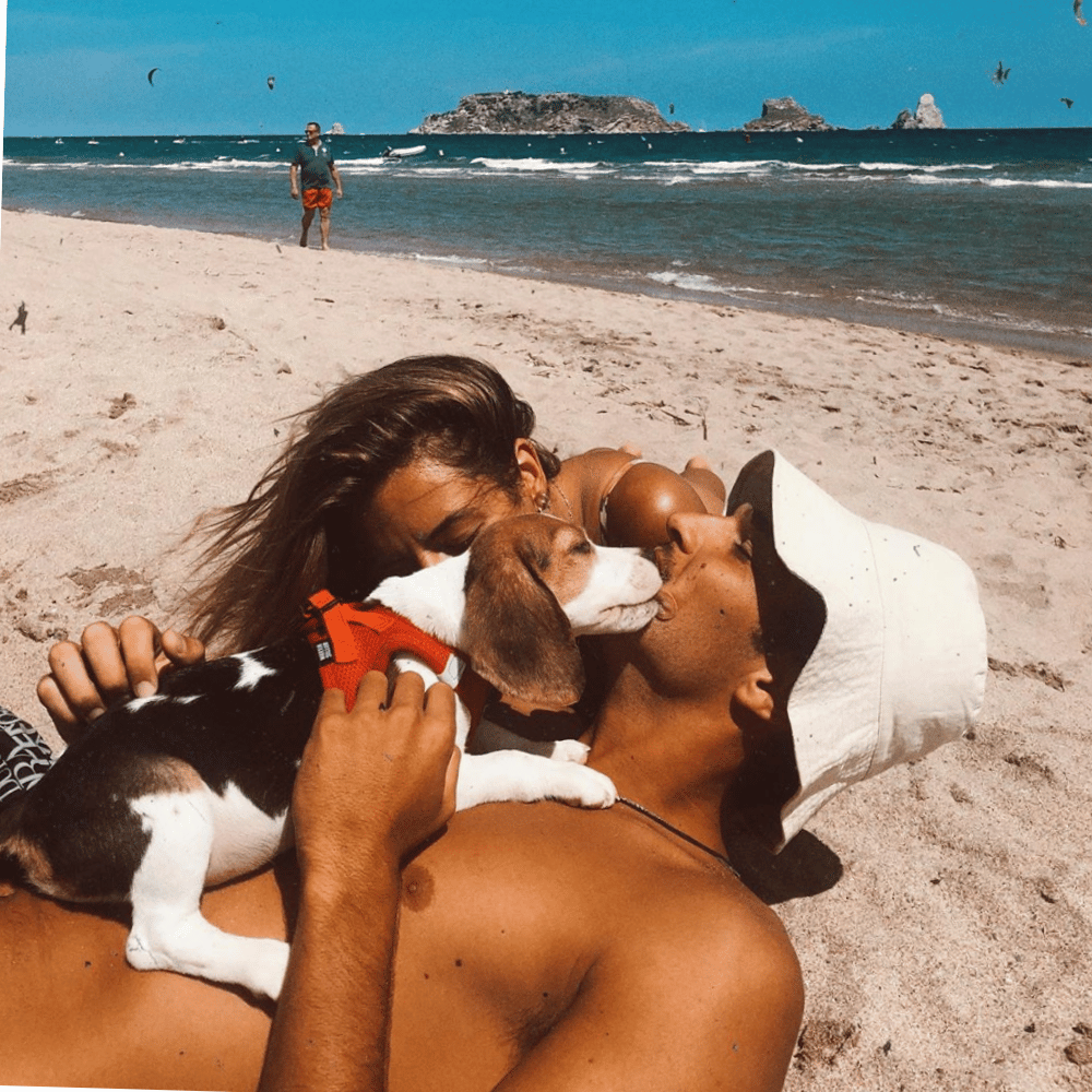 woman and boyfriend at the beach with bucket hat and lovely dog